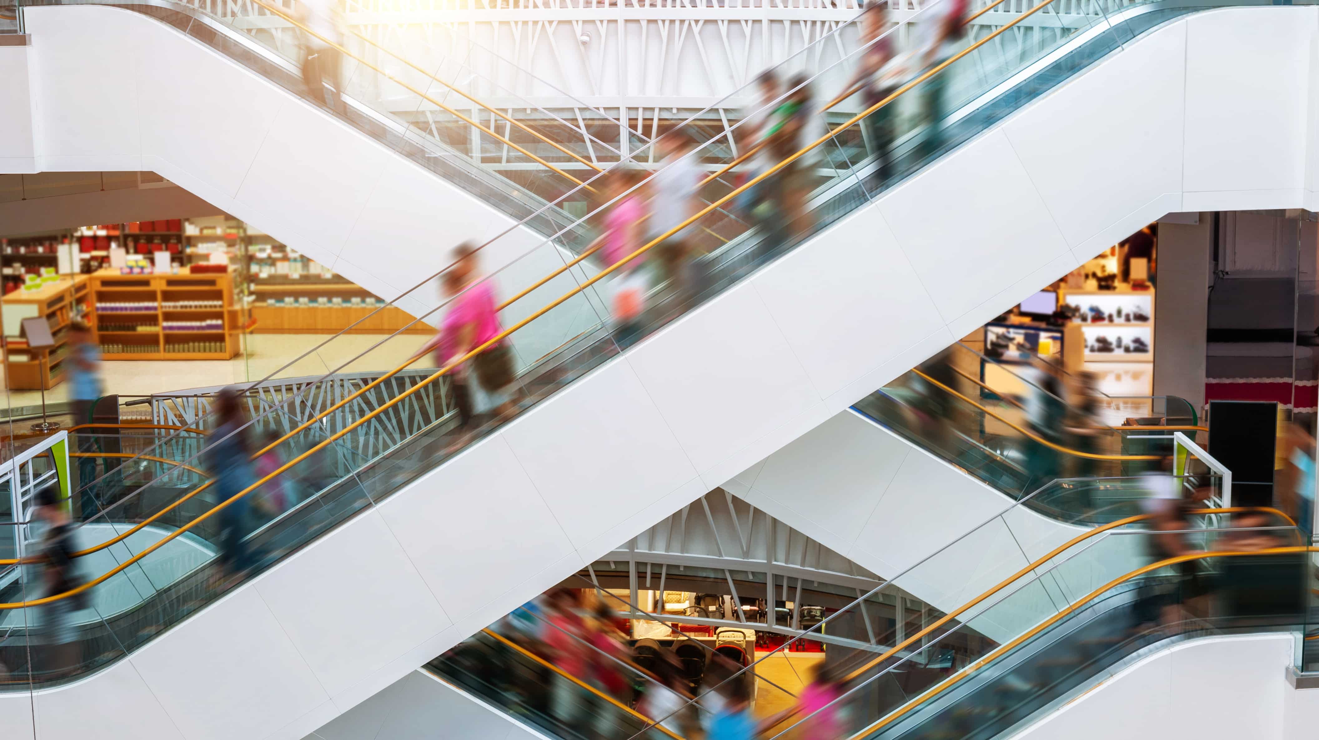 People riding escalators in mall